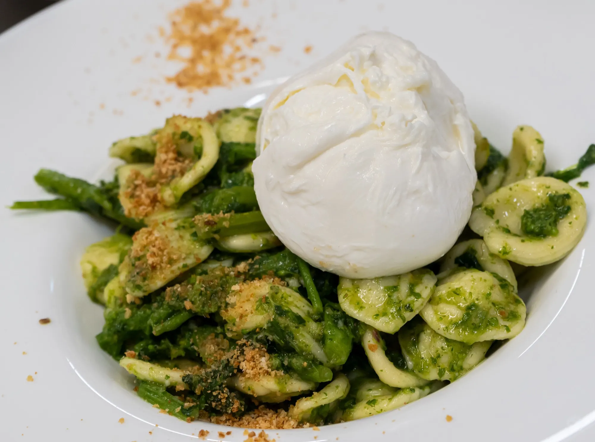 Orecchiette aux légumes verts et chapelure dorée, surmontées d’une burrata